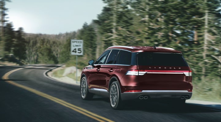 A 2024 Lincoln Aviator® SUV is being driven on a winding mountain road | Klaben Lincoln of Warren in Warren OH